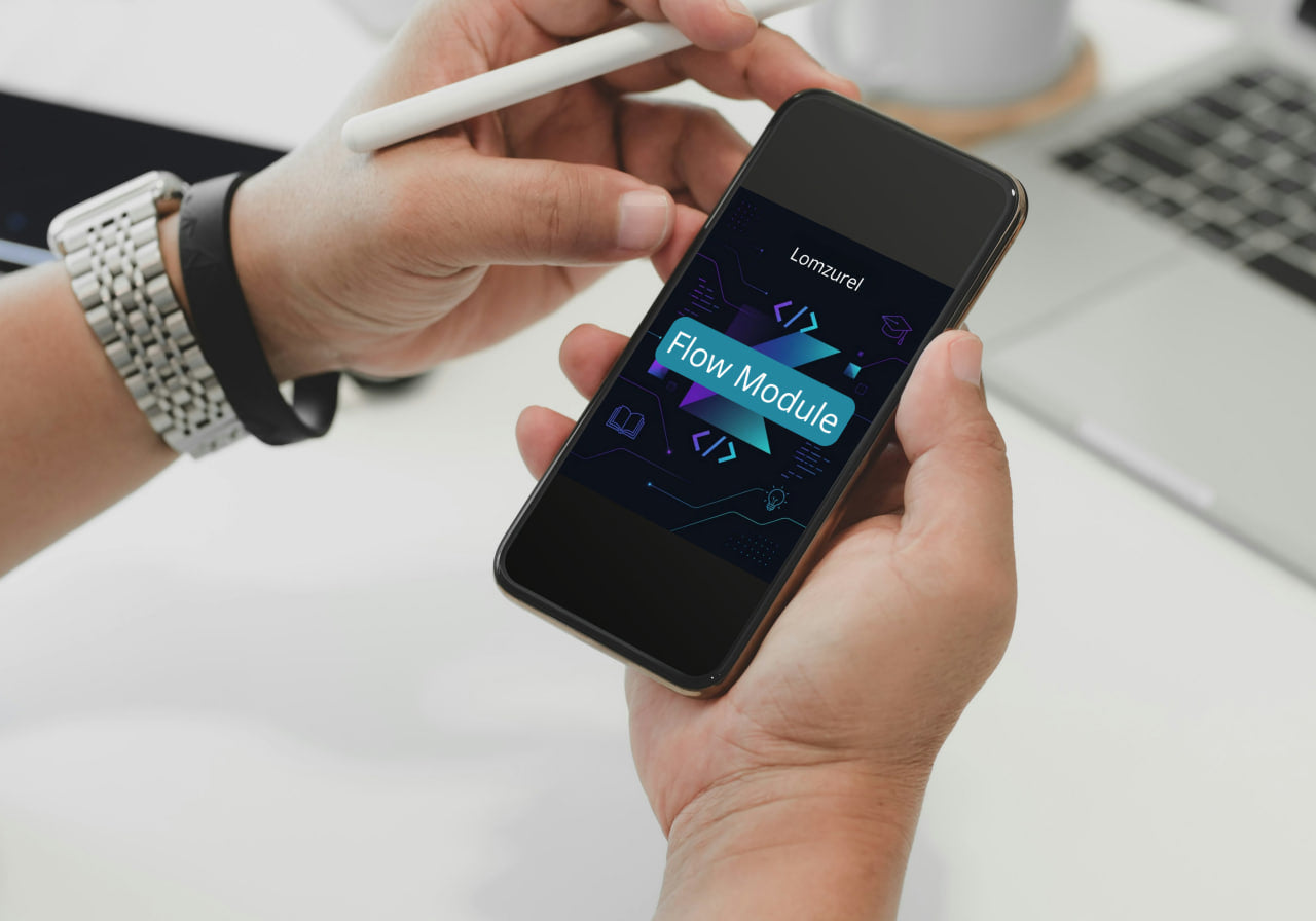 Person holding a smartphone with a software development interface on a blurred office background